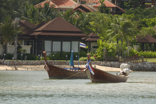 two longboats docked in front of a cafe at bang tao