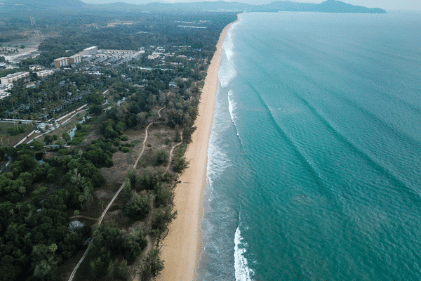 aerial drone image taken above mai khao beach looking towards the local housing area