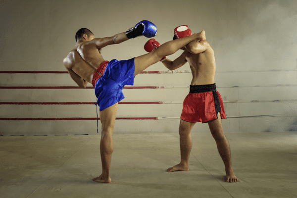 two Muay Thai fighters in Phuket posing mid kick