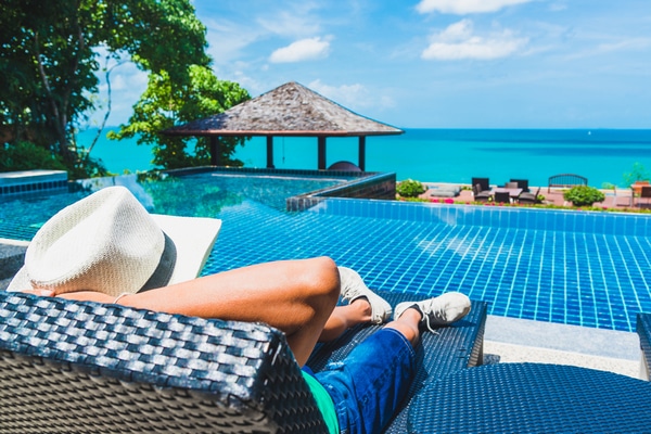 a man with white hat lies in a sunbed overlooking the andaman sea