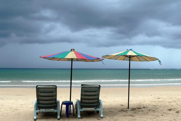 Rainy weather arriving on a deserted beach in Phuket