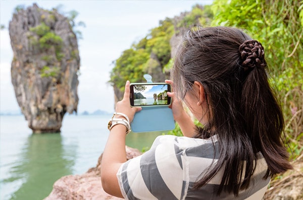 Woman taking pictures of Phang Nga Bay
