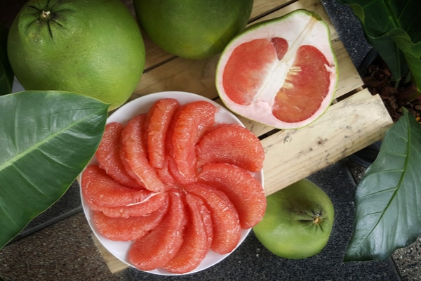 sliced pomelo placed on a kitchen platter