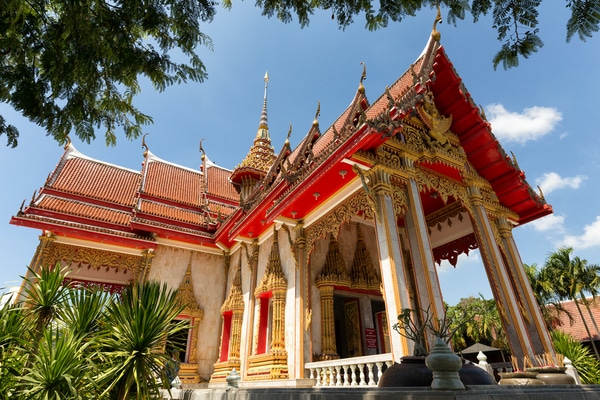 a photo of the wat chalong temple entrance with people awaiting entry
