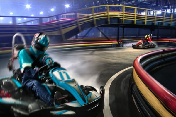 two go karters drifting around a track at nighttime