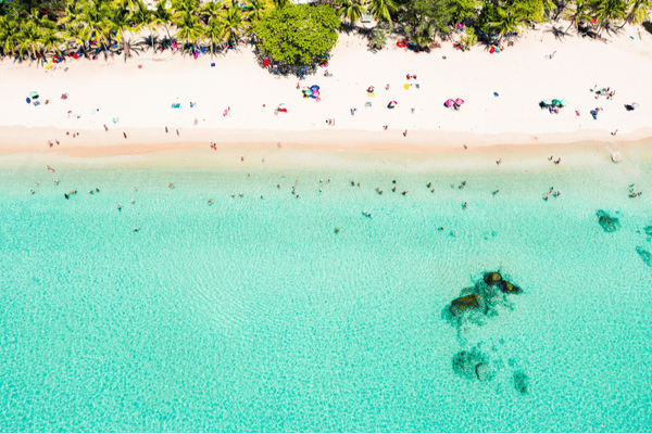 a birds eye view of the white sandy beach and crystal clear waters