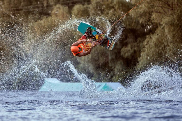 a man performs a difficult trick while wakeboarding in Phuket