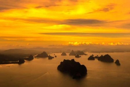 Aerial view of a stunning sunset of Phang Nga bay, showcasing vibrant colors reflecting on the water