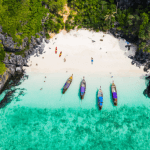 an aerial view of the Phi Phi Islands with 4 boats anchored close to shore