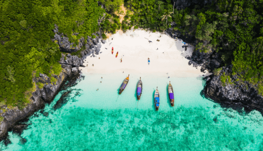 an aerial view of the Phi Phi Islands with 4 boats anchored close to shore