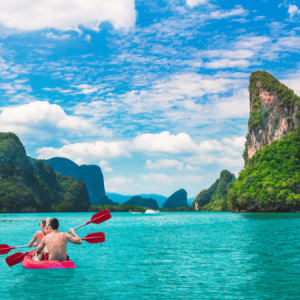 A couple kayaking in Ko Tapu, surrounded by towering limestone cliffs and clear waters.
