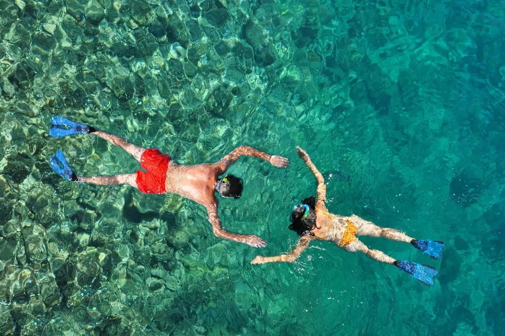 a male and female couple embracing the experience of snorkeling in phuket at the phi phi islands