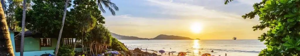 Sunset over beach with people walking