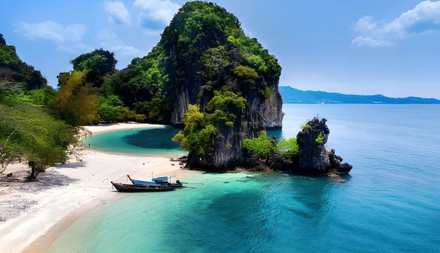 Aerial view of Krabi Island. Traditional longtail boats are anchored near the shore.