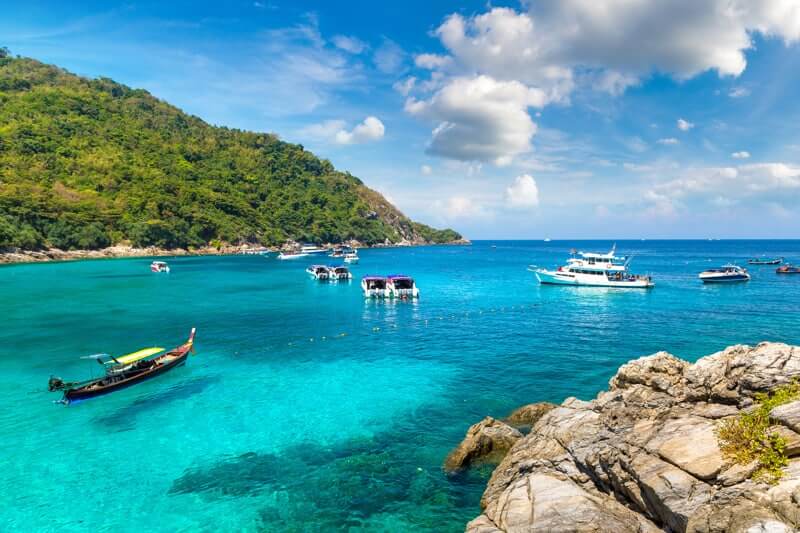 boats anchored in the shallow waters at koh rachai yai
